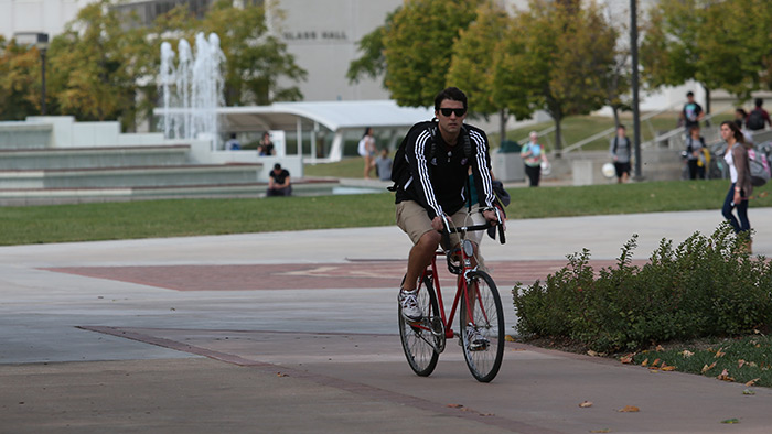 MSU student riding a bicycle on campus. 