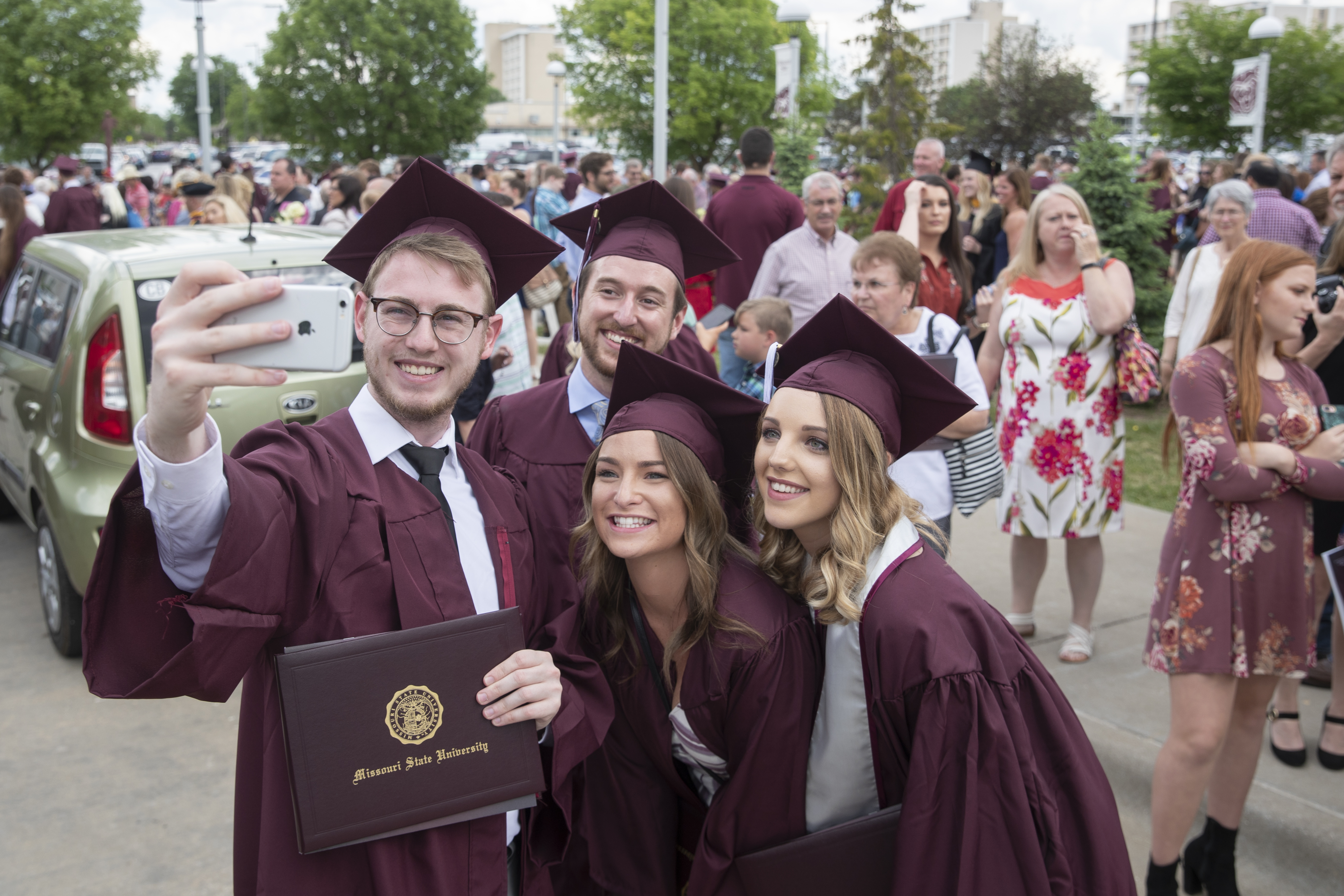 Missouri State graduates taking a selfie in their cap and gown